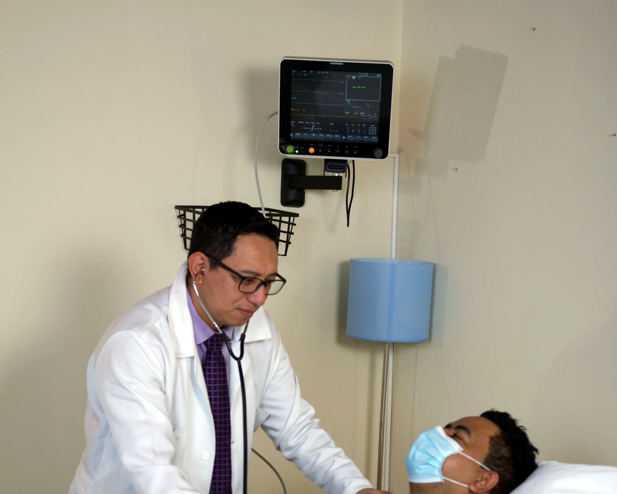 Médico de OncoCare atendiendo a un paciente en su habitación